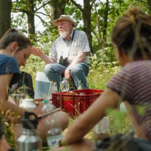 Mann mit weißen Bart der anderen Personen etwas erklärt